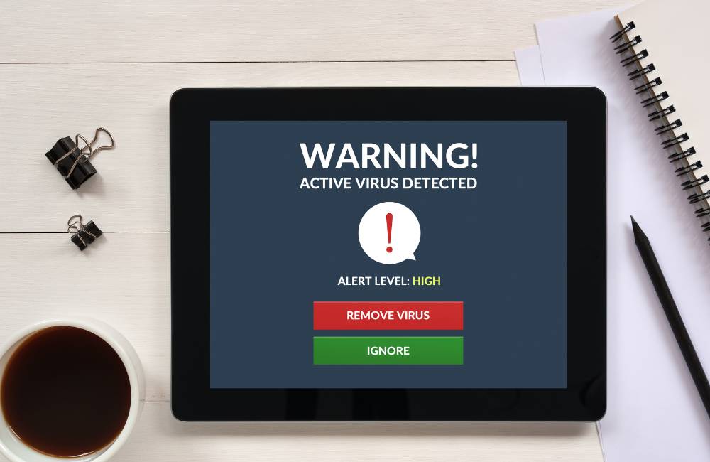 タブレットに「WARNING! ACTIVE VIRUS DETECTED（ウイルス検出）」の警告画面と、削除・無視のボタンが表示されています。