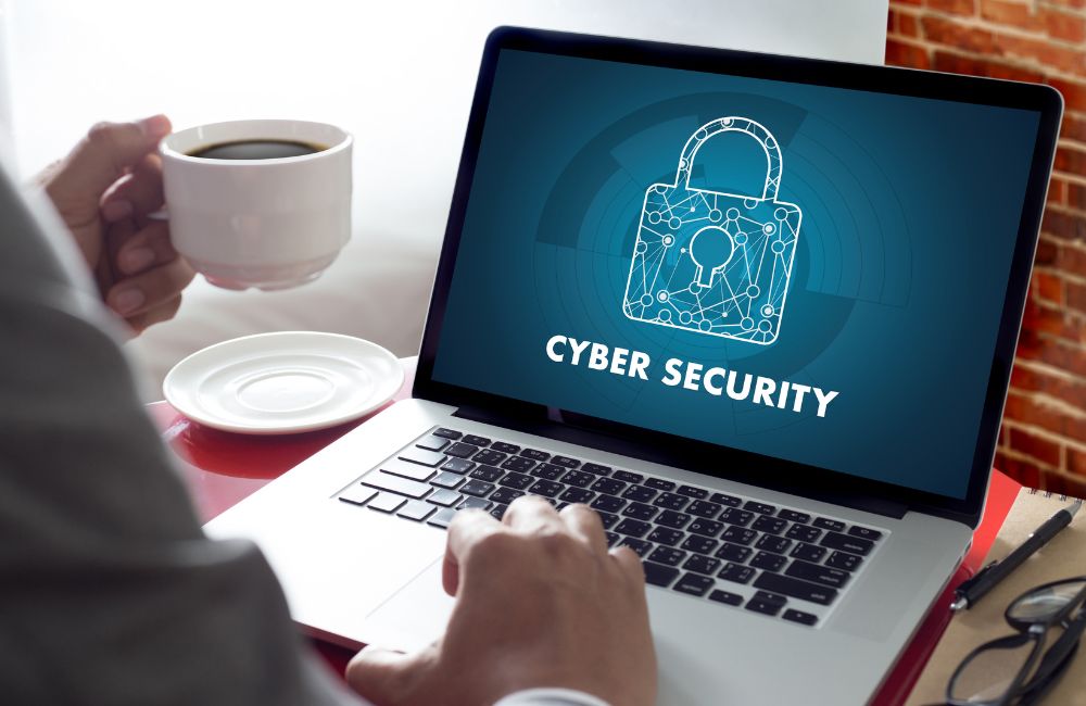 ノートパソコンの画面に鍵とCYBER SECURITYの文字が表示されているセキュリティ対策のイメージ