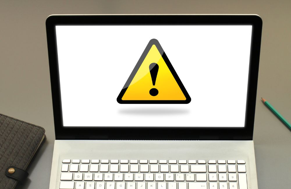ノートパソコンの画面に表示された黄色い警告マーク