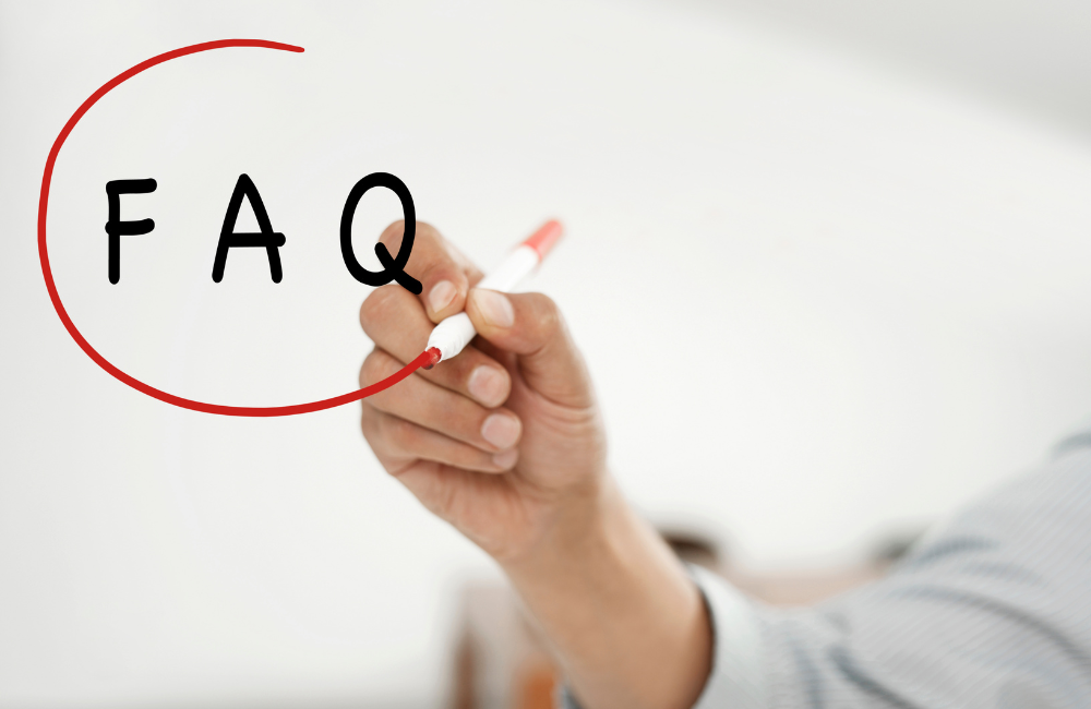 白いボードに黒いペンで「FAQ」と書き、赤いマーカーで丸を囲んでいる手元