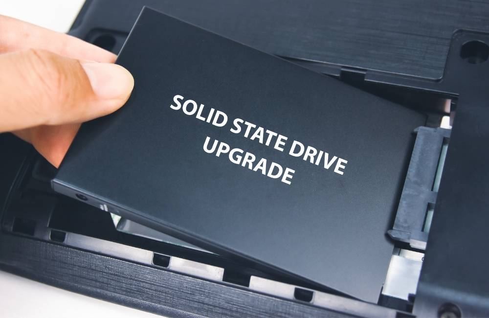 パソコンの基板にあるスロットに、新しいM.2 SSDを慎重に差し込もうとしている手元のアップ