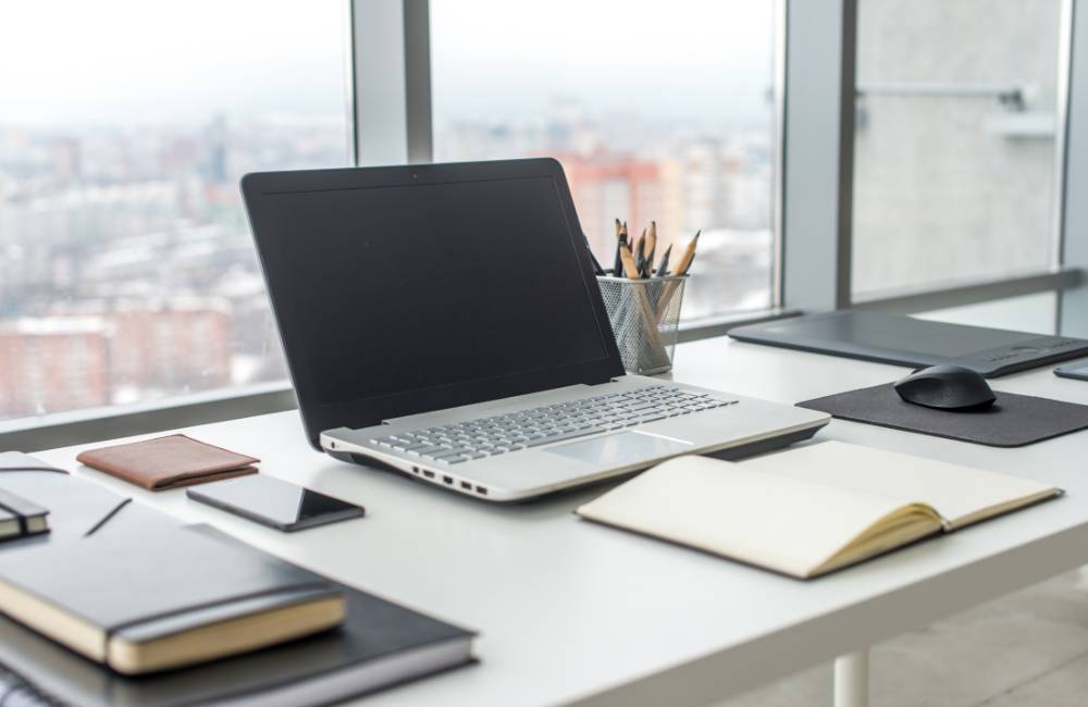 清掃され整ったデスクに置かれた、清潔感のあるノートパソコン