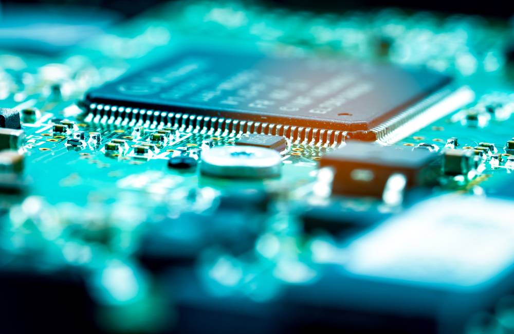 緑色の電子基板の上に、小さな黒いチップや電子部品が並んでいる超接写画像。