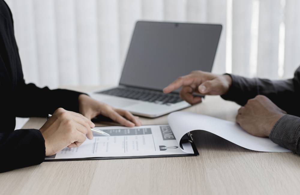 資料を広げて、大切なポイントを一つずつ指差して確認している安心感のある手元