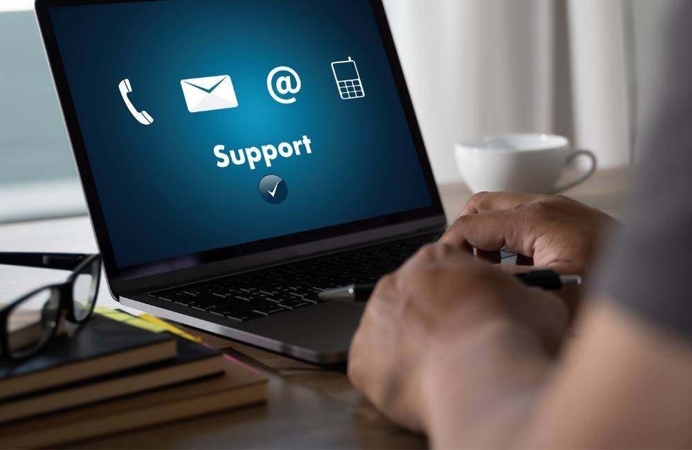 パソコンの画面に、電話やメールのマークと一緒に「Support（サポート）」という文字が表示されている様子。