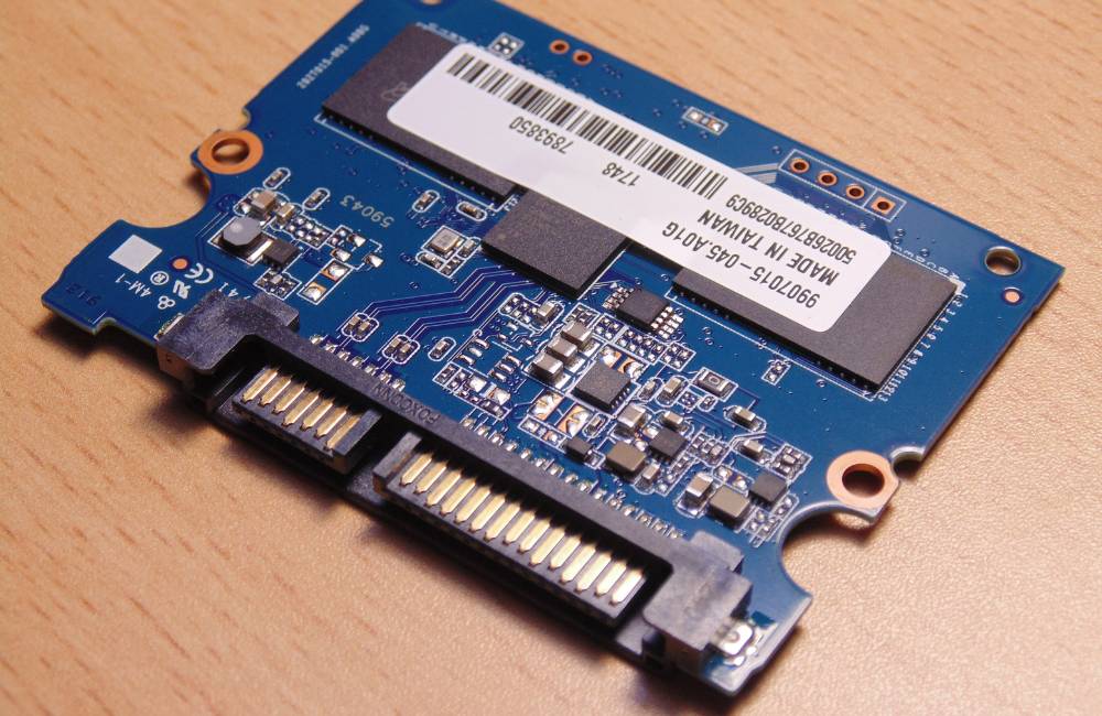 ケースが取り外され、緑色の基板と端子がむき出しになったSSDの内部構造。