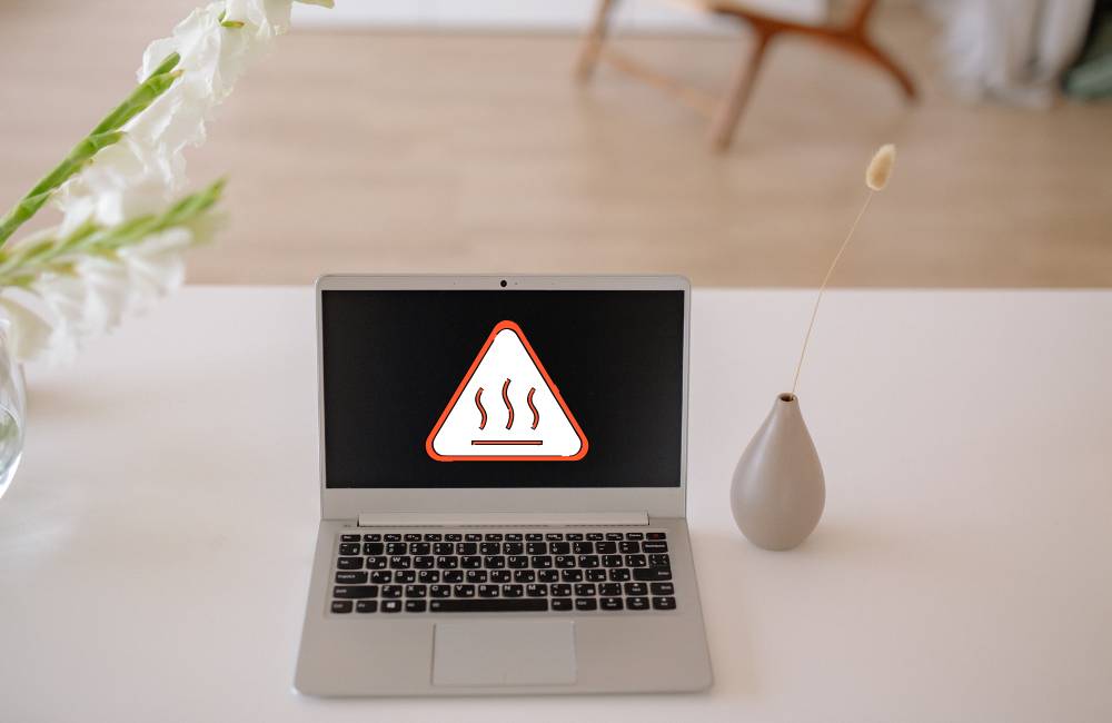 発熱警告マークが表示されたノートパソコン。中古PCの熱トラブルを示すイメージ