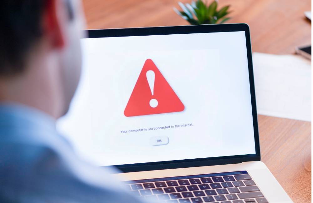 警告マークが表示されたノートパソコン画面。中古PCで起こりやすいエラーや不具合を示すイメージ