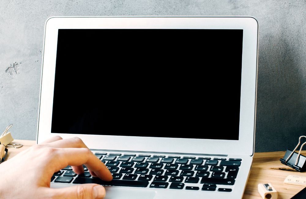 画面が真っ暗で起動しないノートパソコンを確認している様子