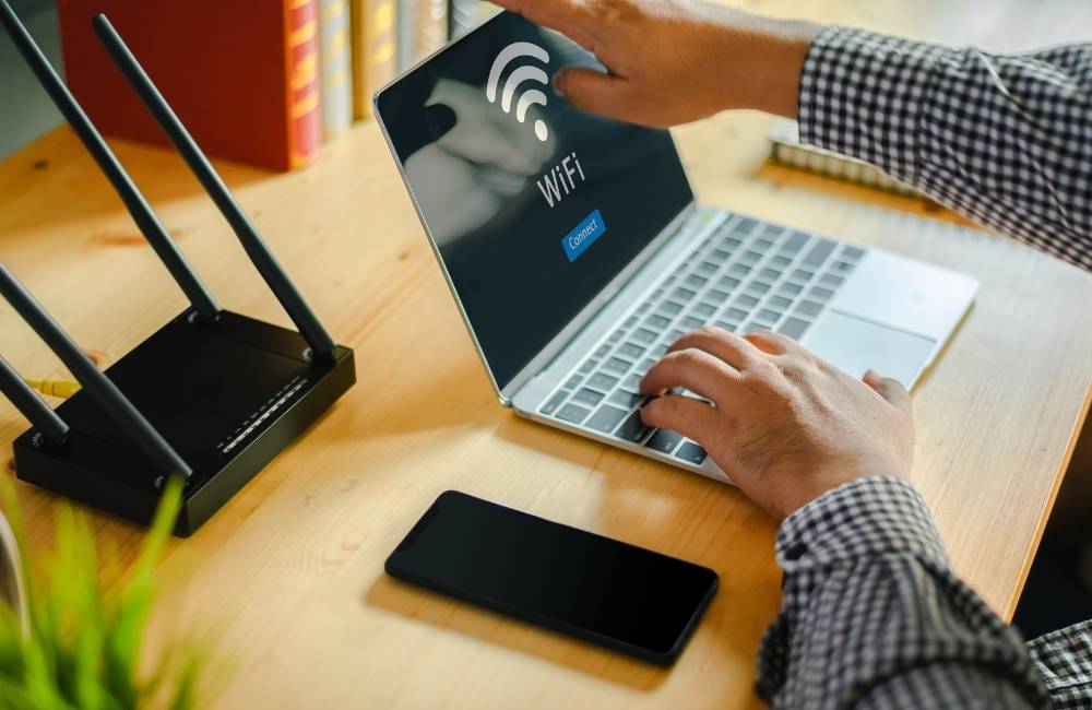 ノートパソコンの画面に大きく表示されたWi-Fiマークに、優しく指を触れて接続を確認しようとしている様子。