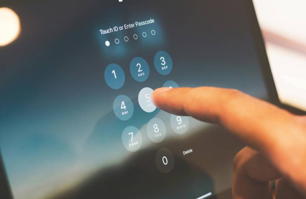 タブレットの画面に表示された数字を、指でトントンと押している手元。
