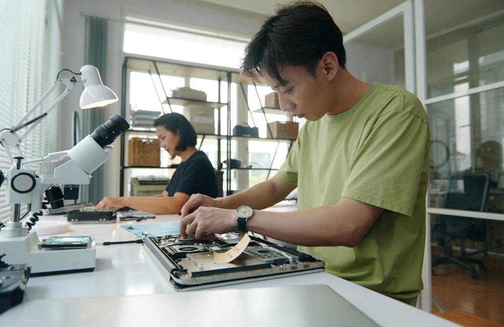 中古パソコン専門店で、技術者が分解したPCを丁寧に整備・データ消去作業している様子