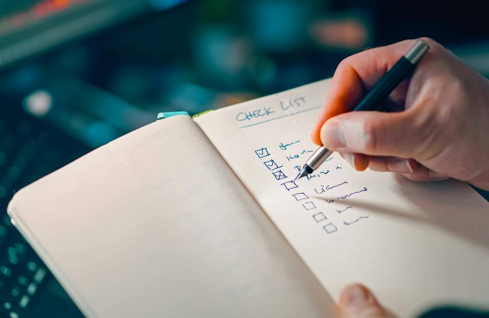 パソコンを手放す前に確認すべき項目を、ノートのチェックリストに書き出して一つずつ確認している様子