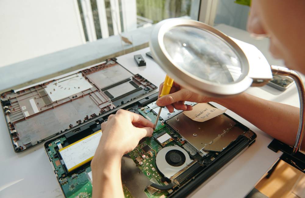 専門店でノートパソコンの内部基板を点検・整備している作業風景