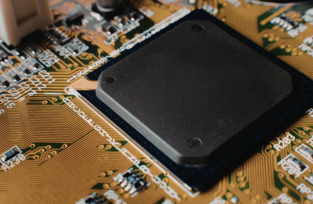 精密な電子回路基板と黒いメインチップセットが搭載された中古パソコンの内部パーツの接写画像