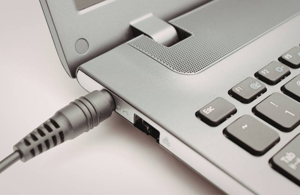 ノートPCの電源ポートに規格がぴったり合う専用ACアダプタが安定して接続されている様子