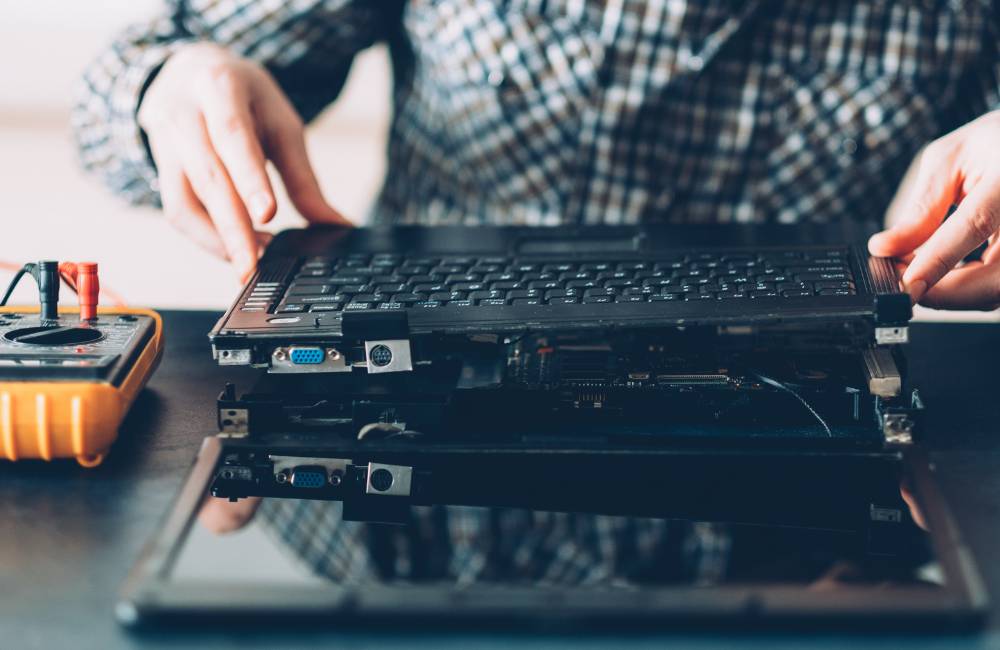 ノートパソコンの内部を丁寧に分解・点検している作業風景(専門店ならではの厳しい品質管理を表現)