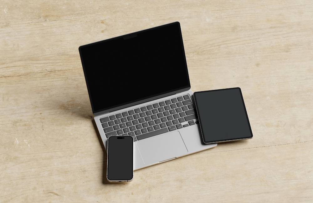 木目調のデスクに置かれた、薄型でスタイリッシュなシルバーのノートPC・タブレット・スマートフォンのセット