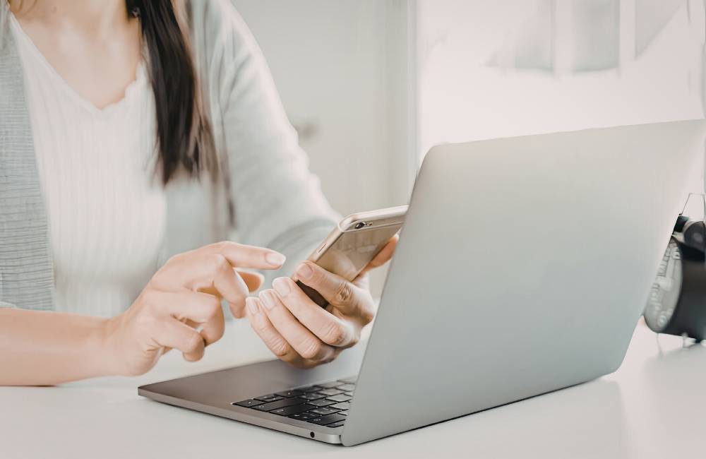 DELLの充実したサポート情報やマニュアルをスマートフォンで確認しながら、ノートパソコンの設定を行う様子