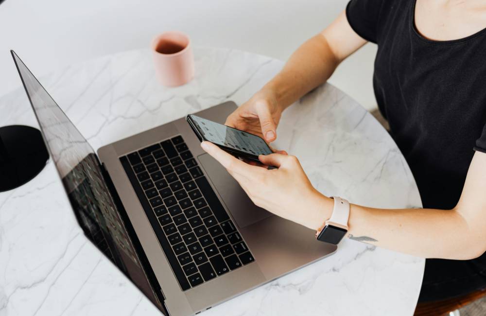 信頼できるショップで購入した高品質なDELLのノートPCとスマートフォンを使い、カフェでスマートに作業する様子