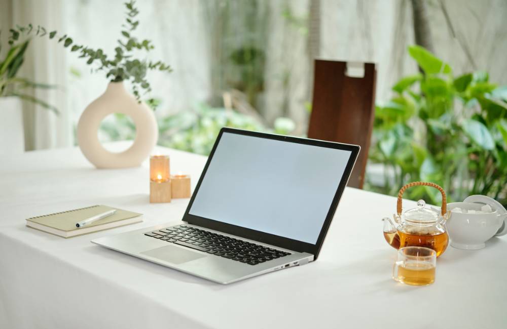 お茶が用意されたリラックスできるテーブルの上のノートパソコン（自分にぴったりの一台を見つけた後の安心感をイメージ）