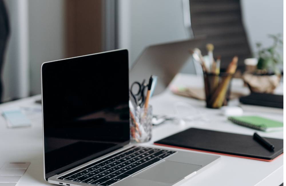 仕事道具が並ぶデスクに置かれた実用的なノートパソコン（中古LIFEBOOKを検討しているビジネスマンや学生への推奨イメージ）