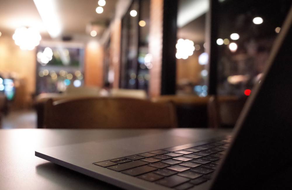 落ち着いた照明のカフェで開かれたノートパソコン（中古でも定評のあるLIFEBOOKの液晶の美しさをイメージ）