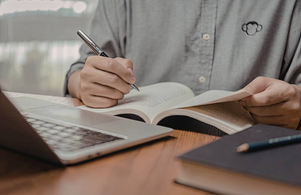 資料を確認しながら手元でペンを持つ様子（中古PC購入時にチェックすべきポイントや注意点をイメージ）