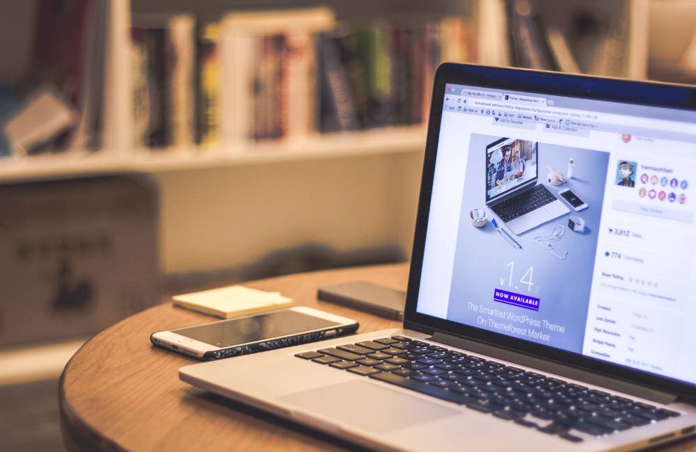 手元のノートパソコンの画面に、多様なウェブサイトのレイアウトやオプションが表示されており、ユーザーが自分に合ったHPのノートパソコンのシリーズやスペックを検討している様子。画面には「1.4」という大きな数字と「NOW AVAILABLE」の文字が見える。