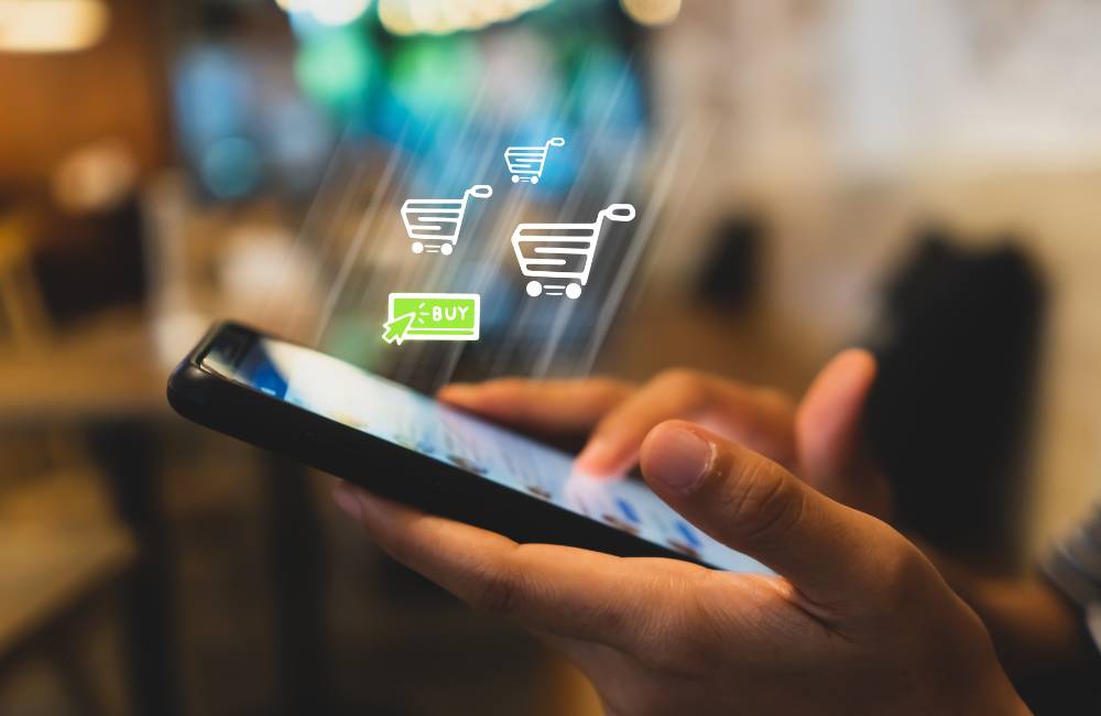 手元に持ったスマートフォンから、ショッピングカートと下向き矢印のアイコンが浮かび上がっている。中古HPノートPCを、信頼できるオンラインショップで簡単かつ安全に購入できることを表している。