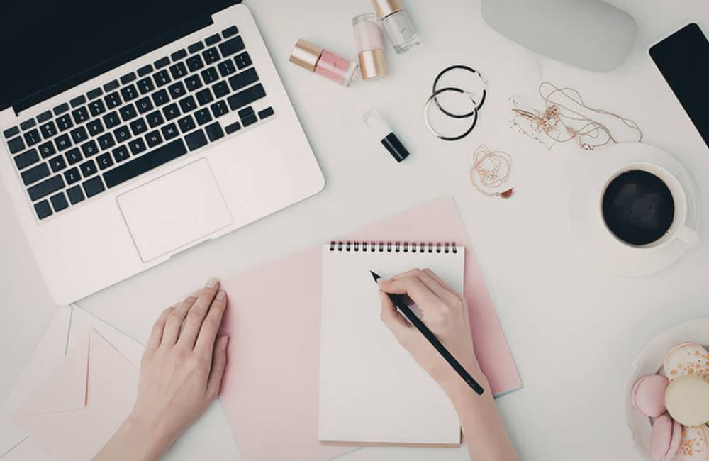 ノートやコーヒーと一緒に置かれたライフスタイルに馴染むMacBook