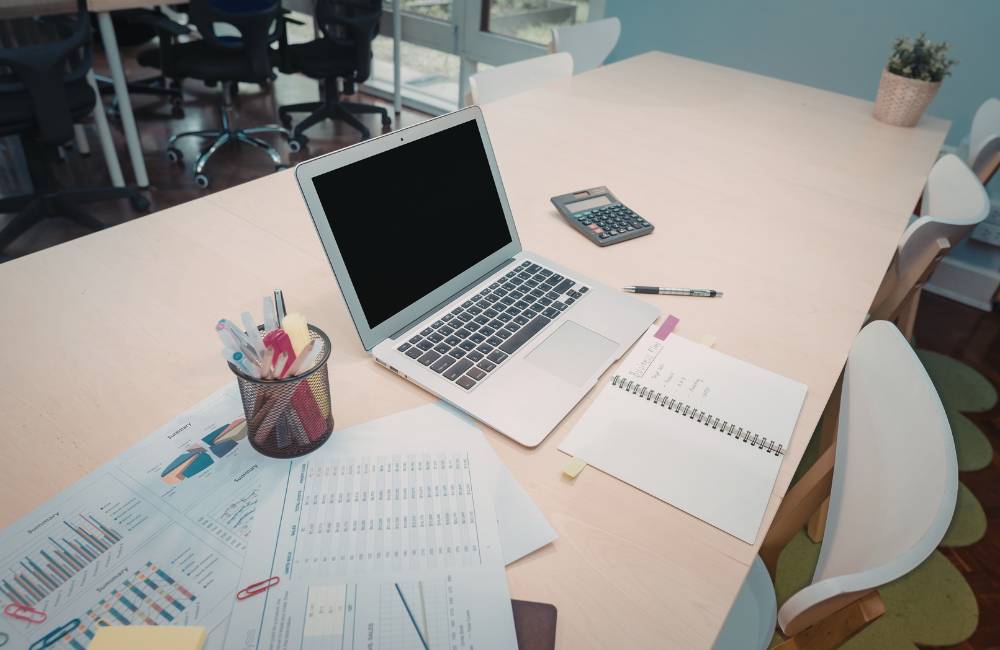 書類や計算機が並ぶデスクにある中古MacBookのチェックイメージ