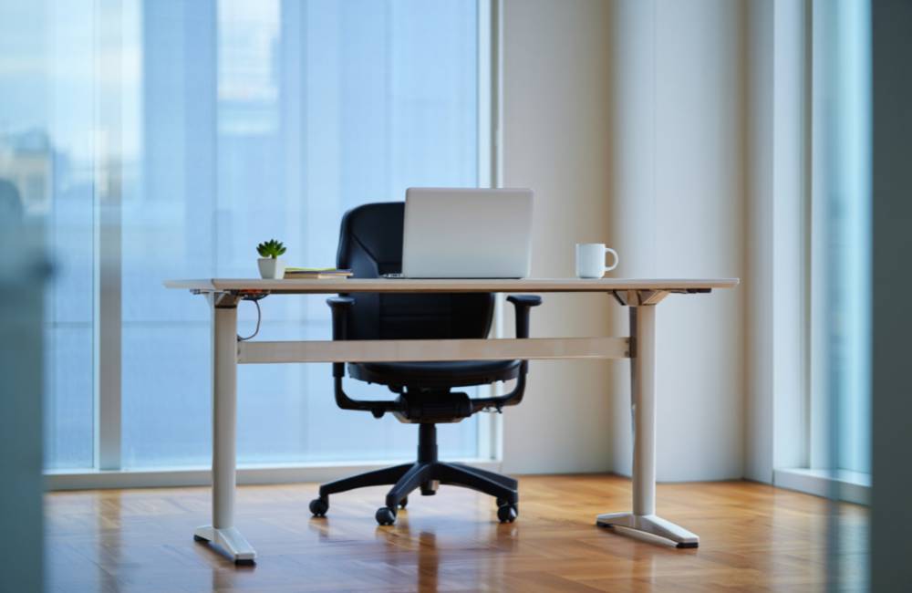 余計なものが置かれていない、清潔感のあるデスクに置かれたシルバーのノートパソコン。