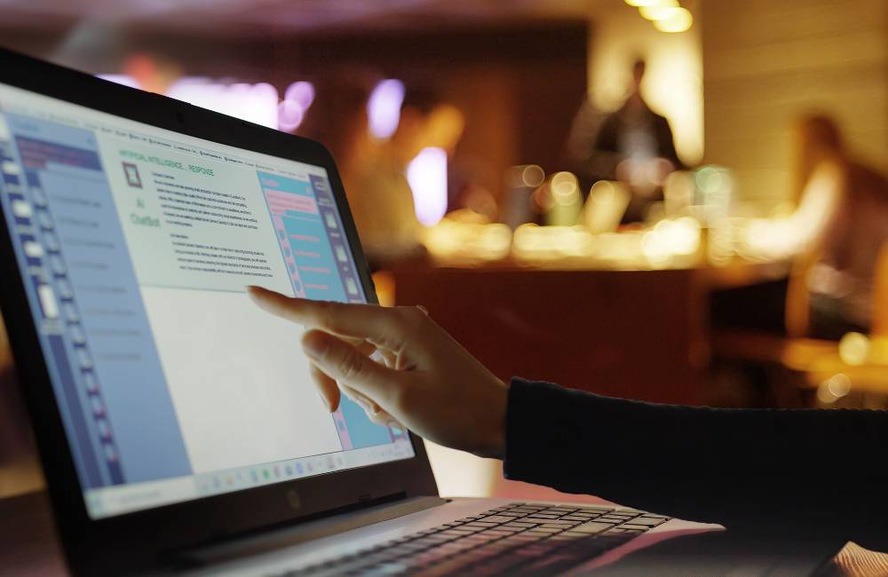 店舗やカフェのような場所で、実際に端末の画面を指さしながら操作感を確認している様子