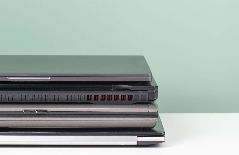 厚みやサイズの異なる複数台のノートパソコンが積み重ねられており、多様なシリーズを比較しているような様子