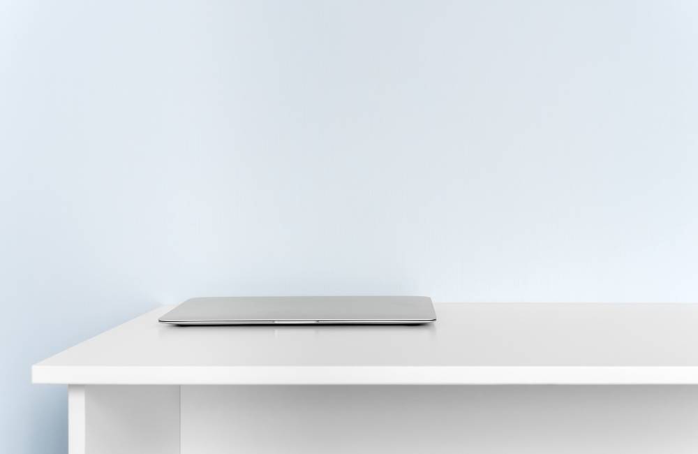 白いデスクの上に置かれた薄型でスタイリッシュなノートパソコンの側面