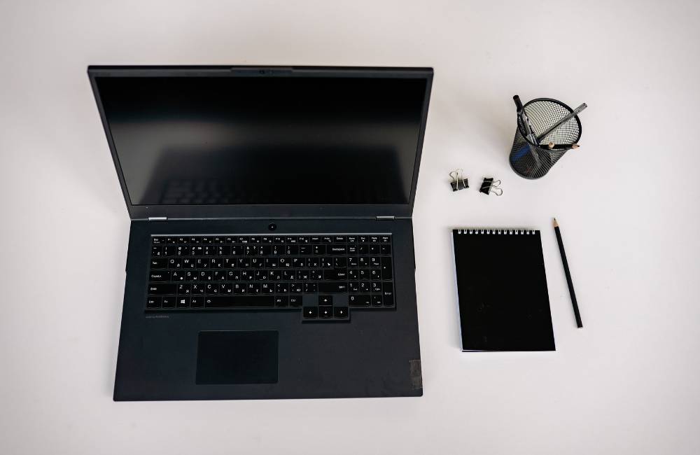 真上から撮影されたノートパソコンと筆記具。記事の内容を整理し、自分に合った一台を見つけられる安心感を演出。