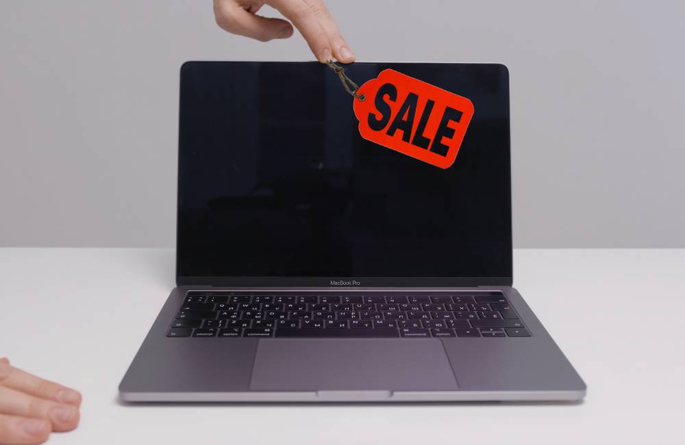 ノートパソコンの画面に「SALE」と書かれた赤い値札が貼られている様子