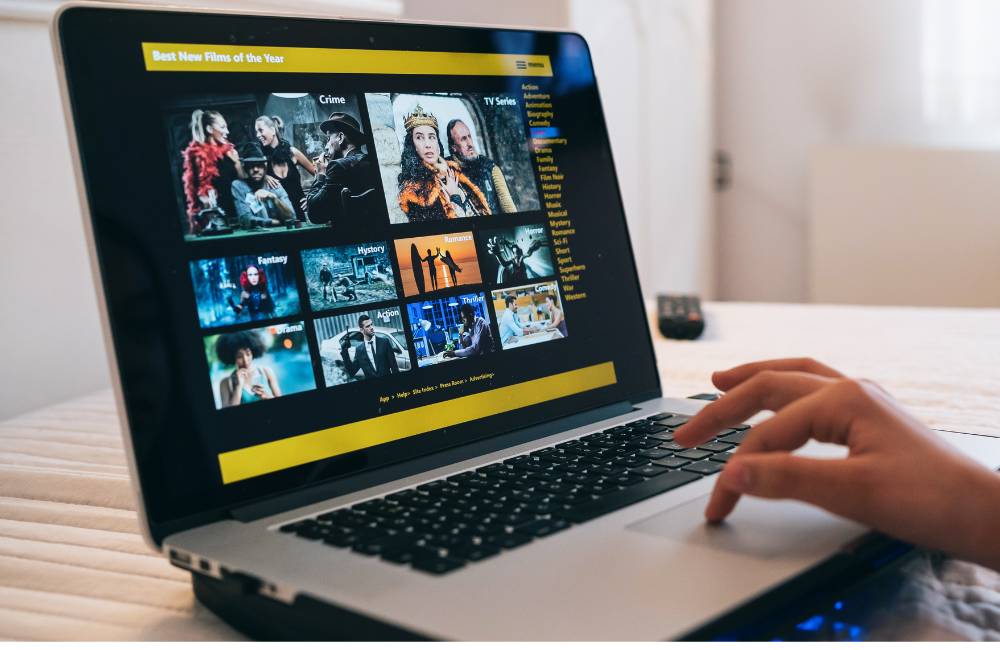 自宅のベッドの上で映画配信サイトを閲覧しているノートパソコン