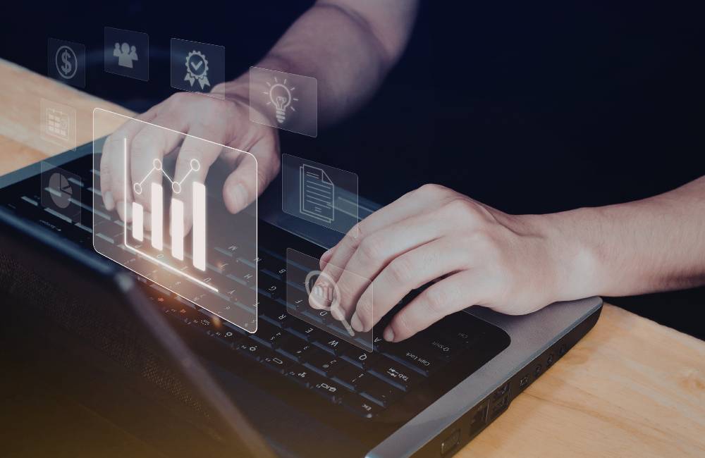 ノートパソコンを操作する手元と、品質や信頼性を象徴するグラフやチェックマークのデジタルアイコン