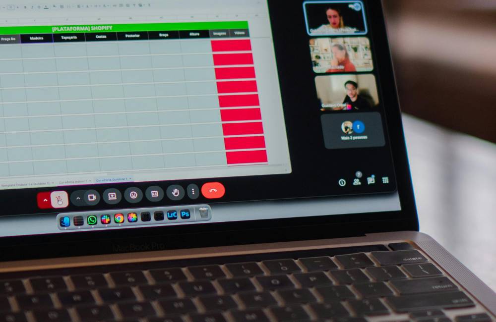 ノートパソコンの画面上で、Shopifyの管理画面（在庫やリスト）を確認しながらオンライン会議を行っているビジネスシーンの接写