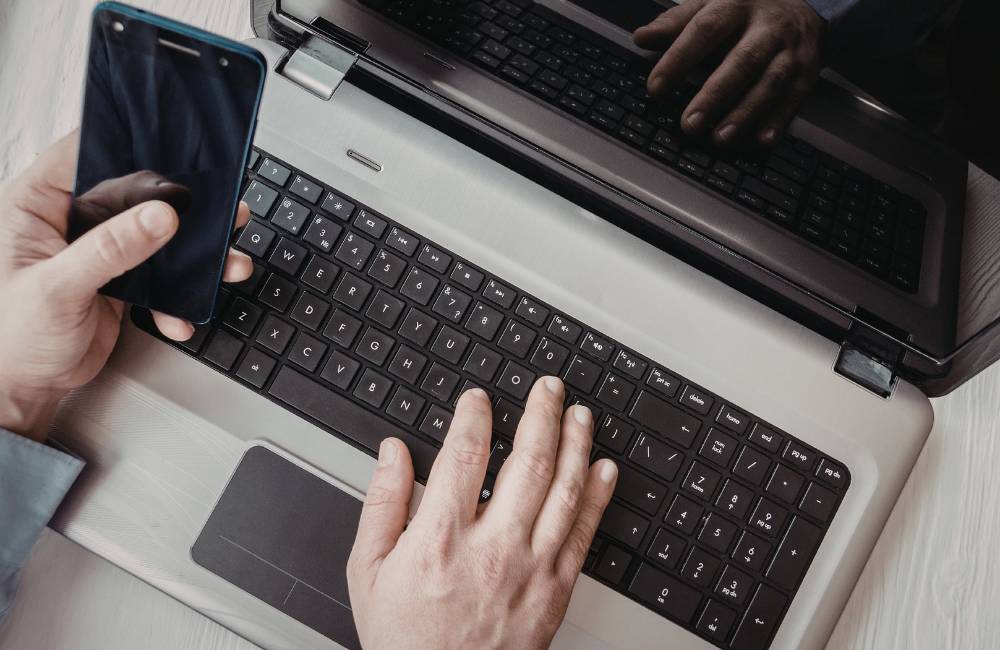 ノートパソコンの画面上で、Shopifyの管理画面（在庫やリスト）を確認しながらオンライン会議を行っているビジネスシーンの接写