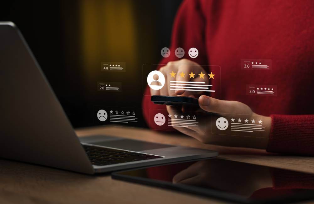 スマートフォンに表示された低い評価の星や、不満を示す顔のアイコンなど、ネット上のネガティブな口コミをイメージした画面