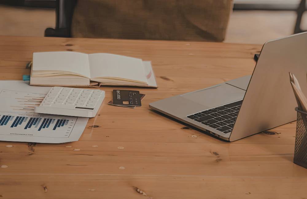 デスクの上に電卓、グラフ資料、クレジットカードが並び、自分に合った1台をじっくり比較検討している場面